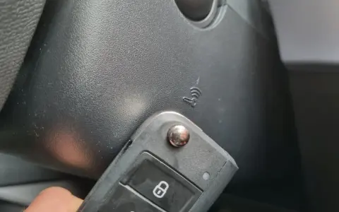 Kluczyk samochodowy z funkcją keyless go w pobliżu przycisku start.
